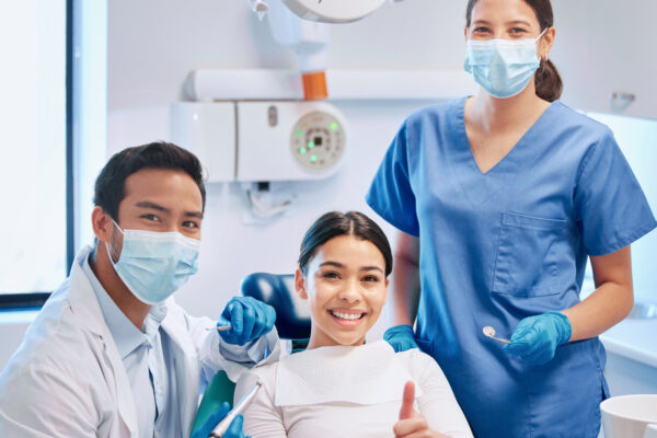 3 (40) Shot of a young male dentist giving the thumbs up with his patient and assistant.